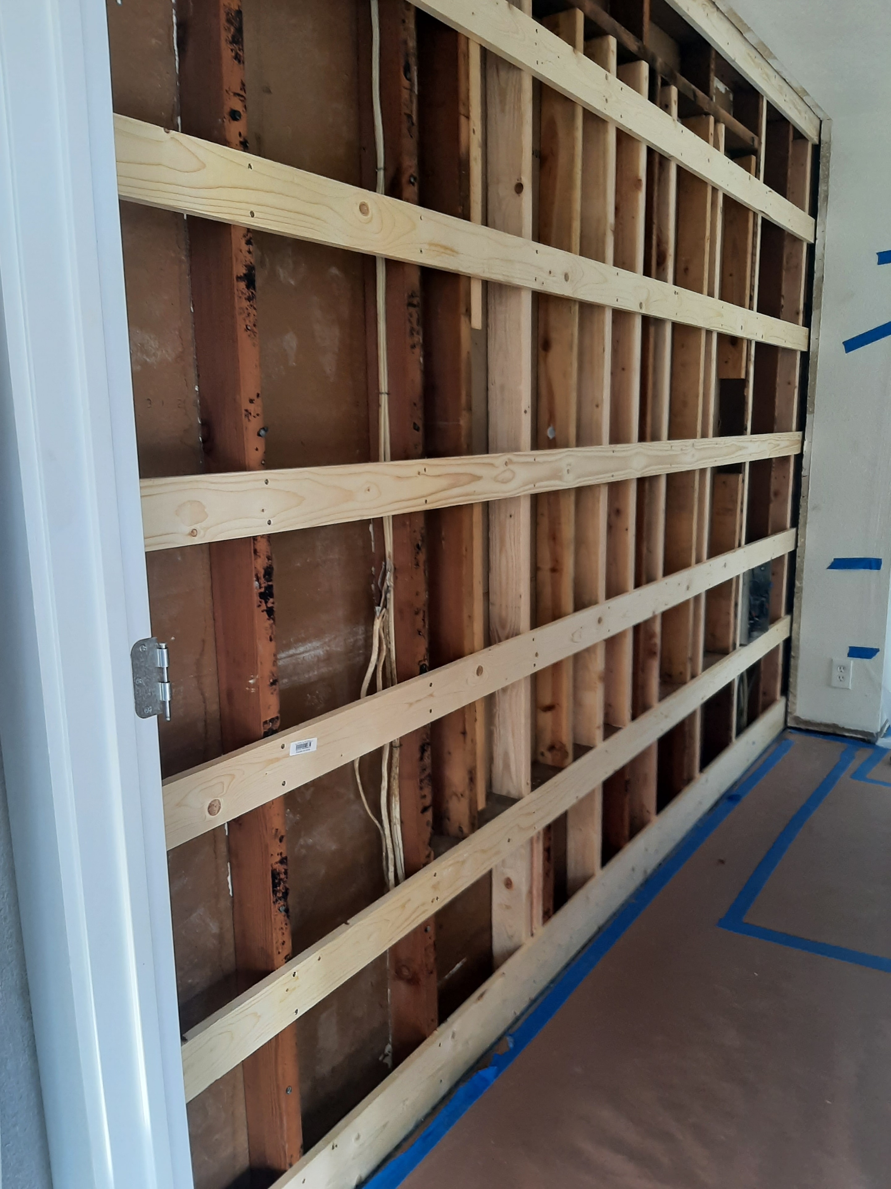New floor joists sistered alongside existing subfloor framing during cabinetry project