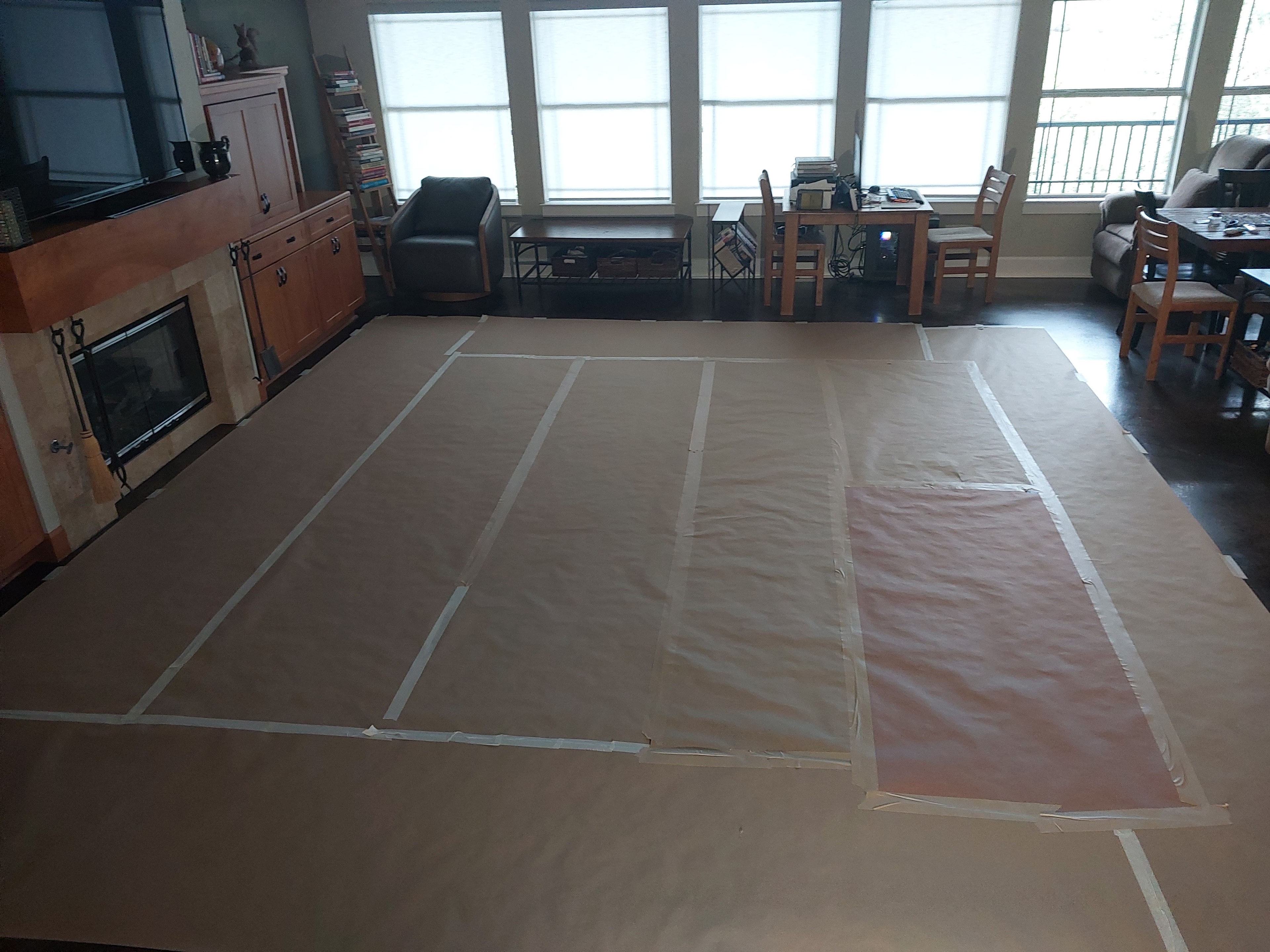 Large living room floor covered with protective kraft paper during interior remodel