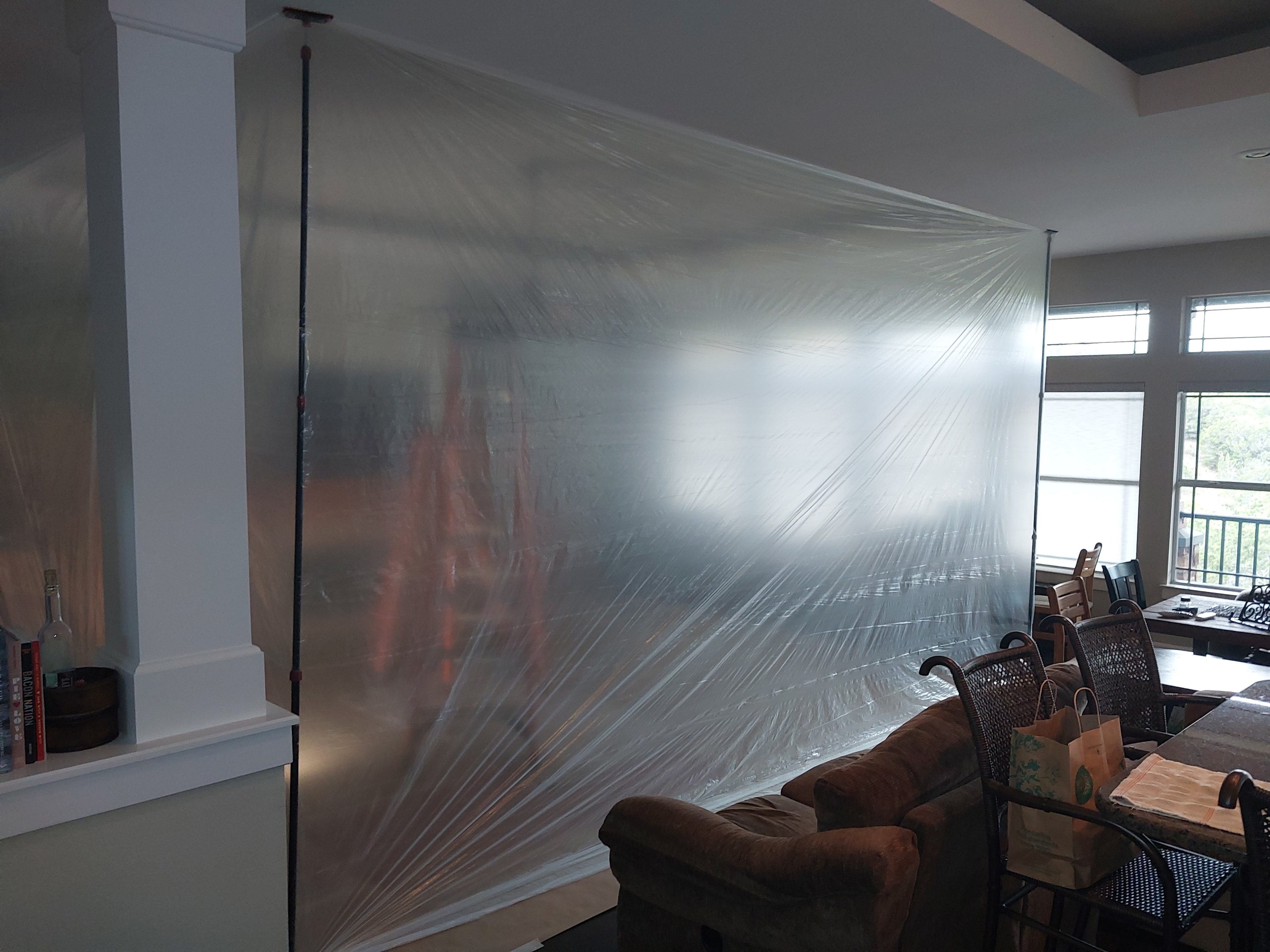 Plastic dust containment barrier hung floor to ceiling during interior remodeling work
